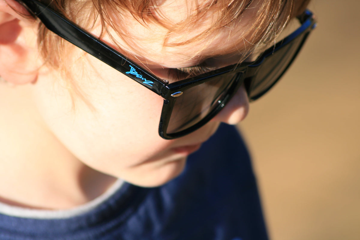 Kids black sunglasses with dark lenses, side temples visible