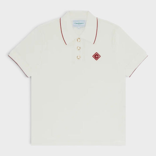 White rib velour polo shirt with red-trim collar and front logo patch, button placket