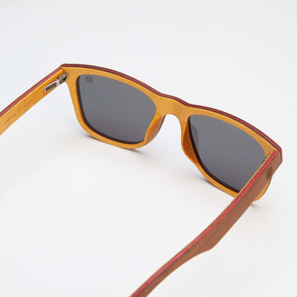 Wood-look sunglasses side view with dark gray lenses and orange trim