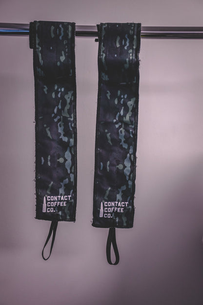 Pair of black and green camo gym wrist wraps hanging with drawstring loops