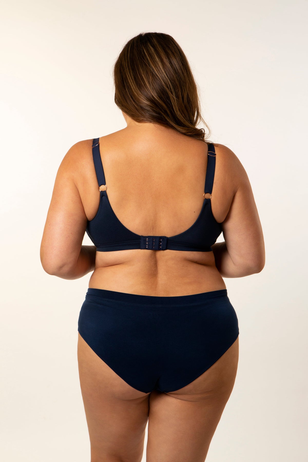 Navy bra back view with adjustable straps and clasp, molded cups and bikini briefs