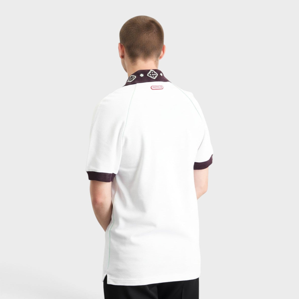 White raglan polo with chenille collar, dark sleeve cuffs, back logo tag