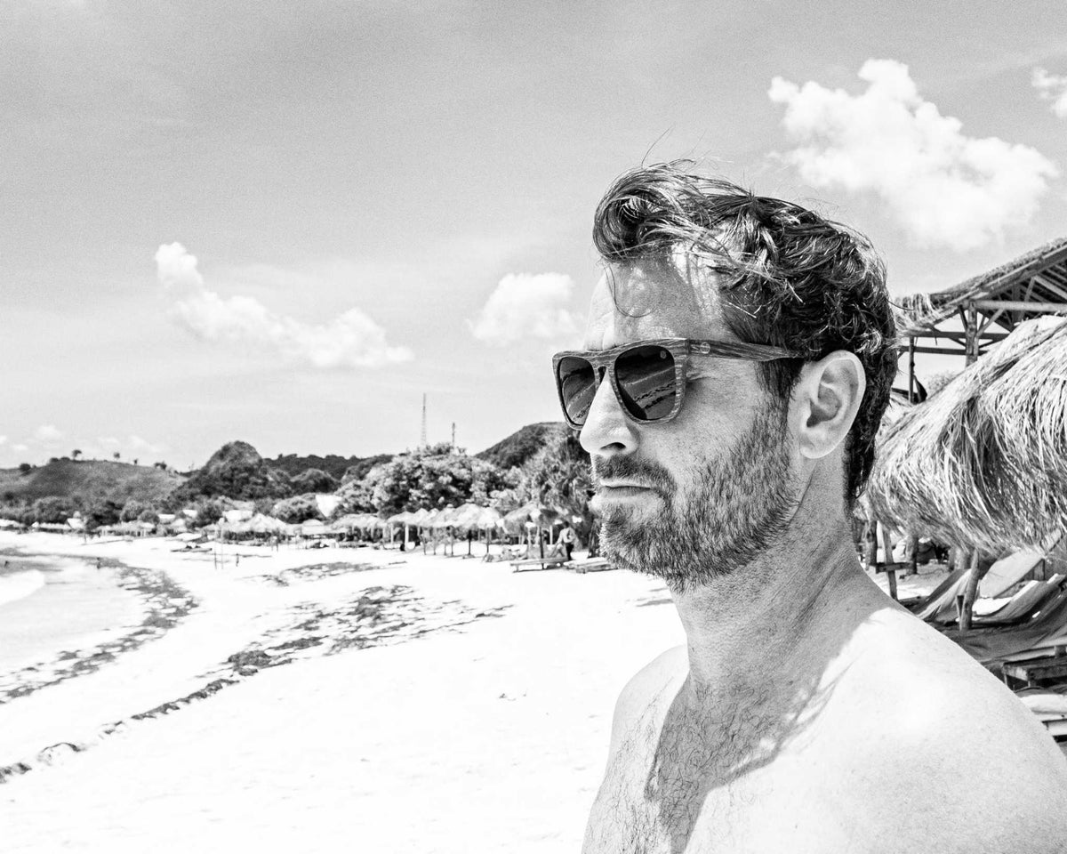 Polarised sunglasses on a man outdoors, dark lenses and brown frame