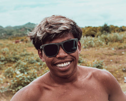 Polarised sunglasses on a smiling person wearing a dark frame and lenses