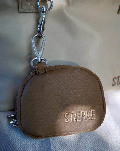 Espresso-brown round zip jewelry pouch with silver keyring clasp and gold logo text