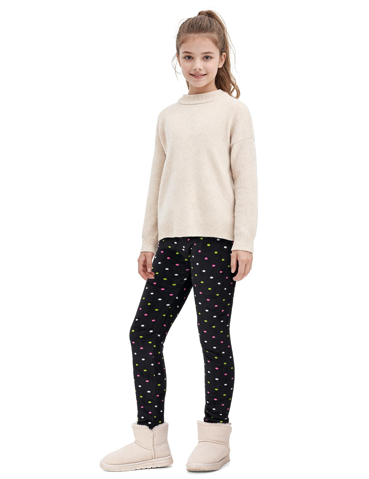 Girls fleece-lined leggings with black multicolor dot pattern, worn with beige sweater
