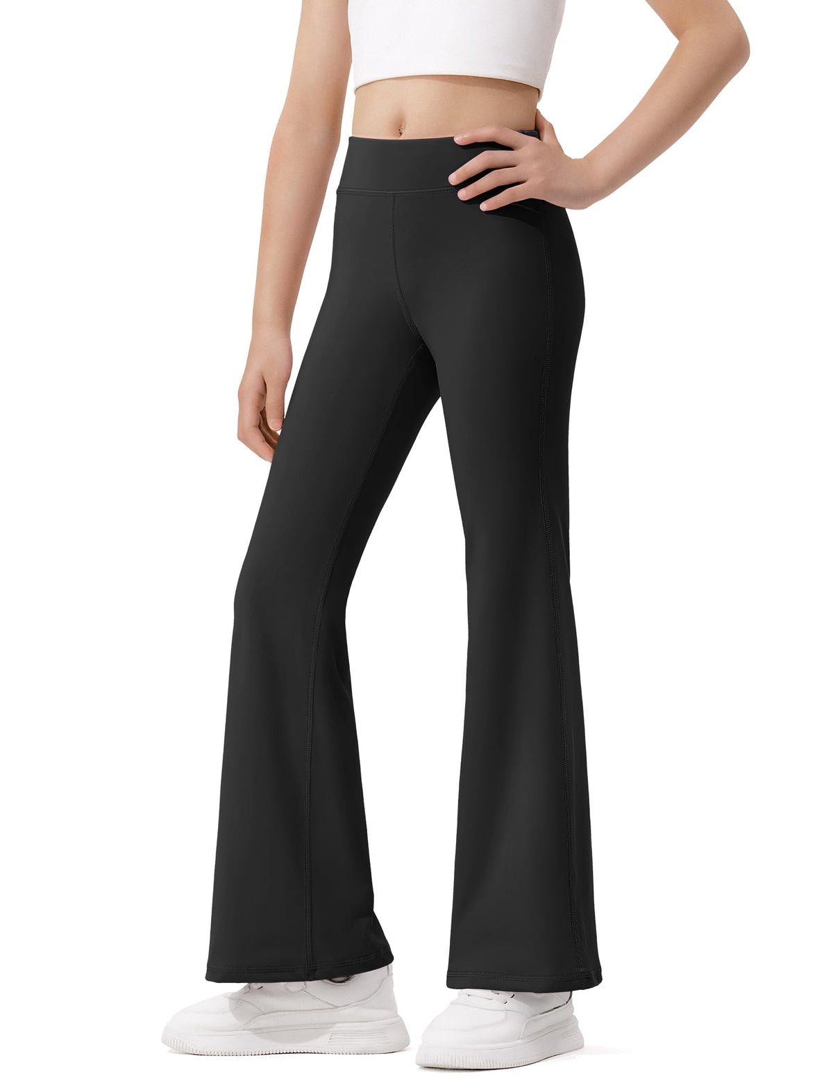 Girls' high-waisted flared leggings in black, back view with hand at waist