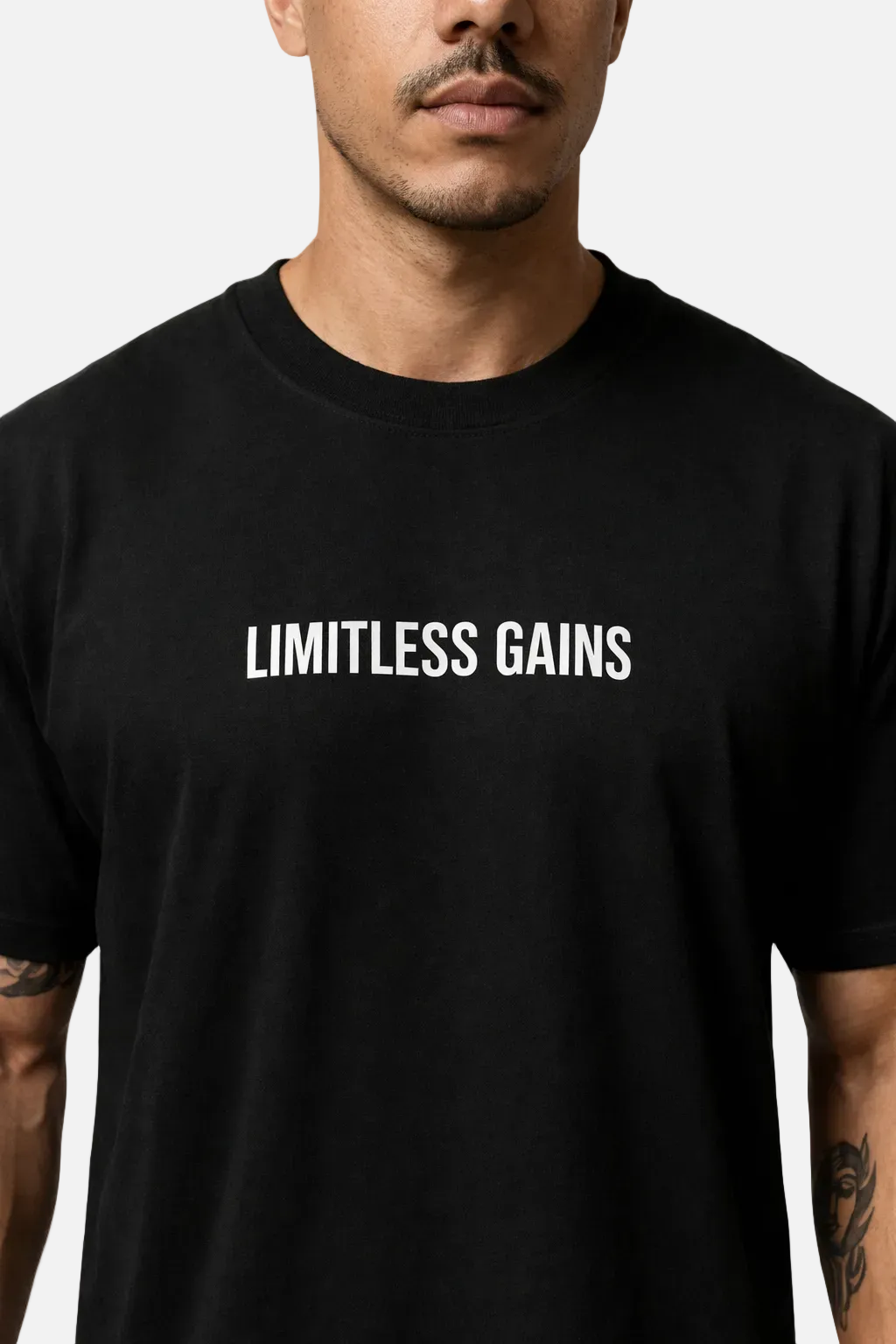 Black men's oversized gym T-shirt with 'LIMITLESS GAINS' front logo close-up