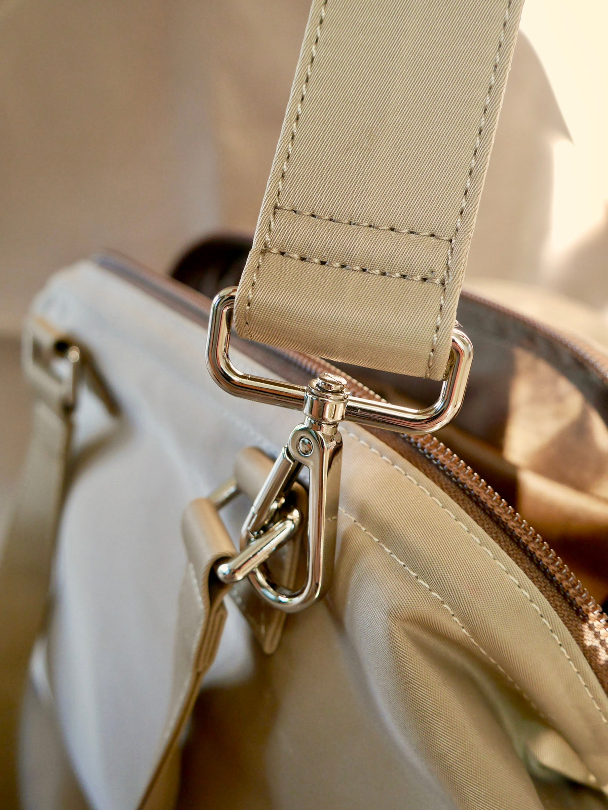 Light beige strap end with metal swivel clips and stitched fabric loop