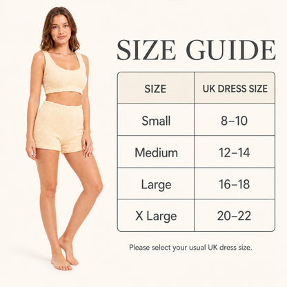 Women’s teddy fleece crop top and shorts pajama set in gold, size guide background