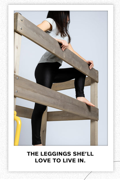 Girls black shiny stretch leggings, full length, worn while climbing and stretching.