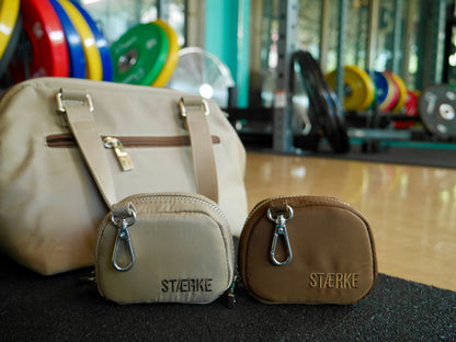 Small zip jewelry pouches, one sand and one espresso, with silver hooks and logo text