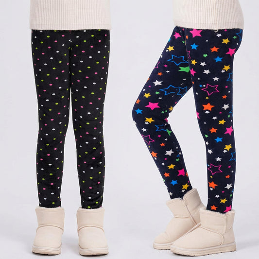 Two pairs of children's leggings shown on lower-body mannequins or models, paired with cream ankle boots. The left pair is black with small multicolored polka dots, and the right pair is dark navy with colorful star prints in pink, blue, yellow, orange, green, and white.