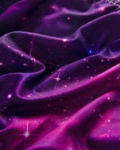 Galaxy print fabric close-up, deep purple satin with bright specks and swirling color