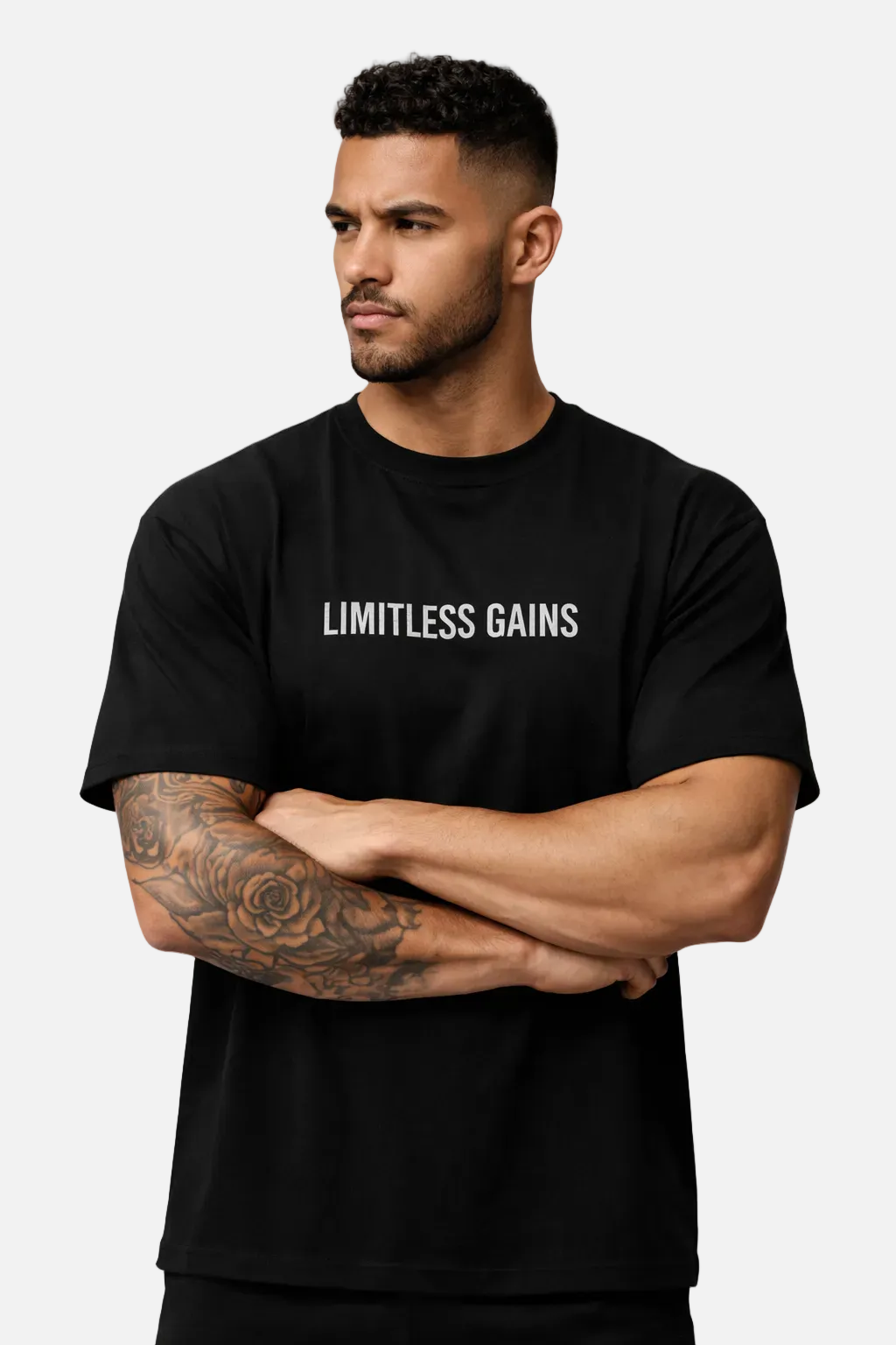 Black oversized gym T-shirt with 'LIMITLESS GAINS' logo, arms crossed