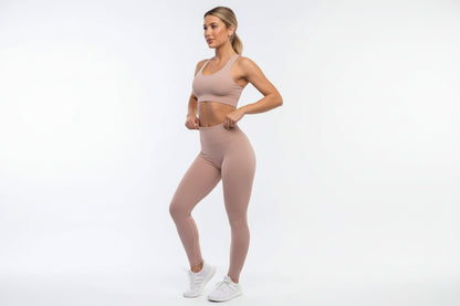 Woman wearing a beige athletic outfit on a white background