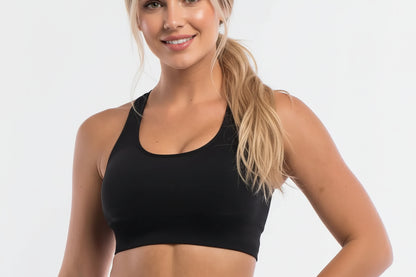 Woman wearing a black sports bra against a white background