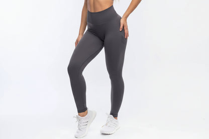 Person wearing dark gray leggings on a white background