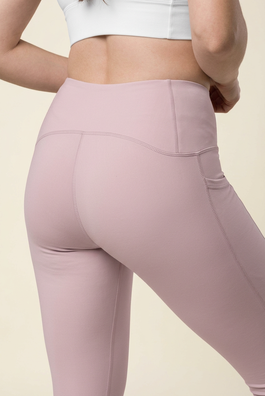 Blush pink high-rise leggings with side pocket detail and curved contour seams
