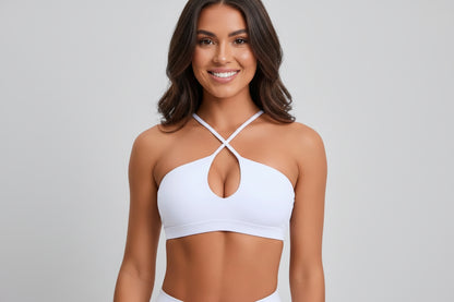 Woman wearing a white bikini top against a plain background