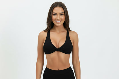 Black sports bra worn by a person on a white background