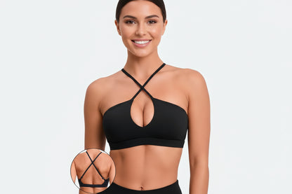 Black sports bra with criss-cross straps on a neutral background