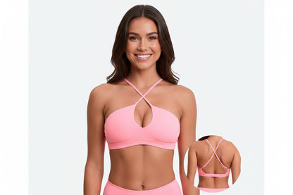 Woman wearing a pink sports bra and shorts with a plain background