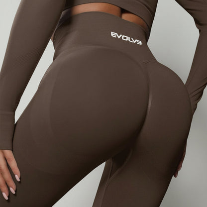 Brown athletic leggings with 'Evolv3' logo on a gray background