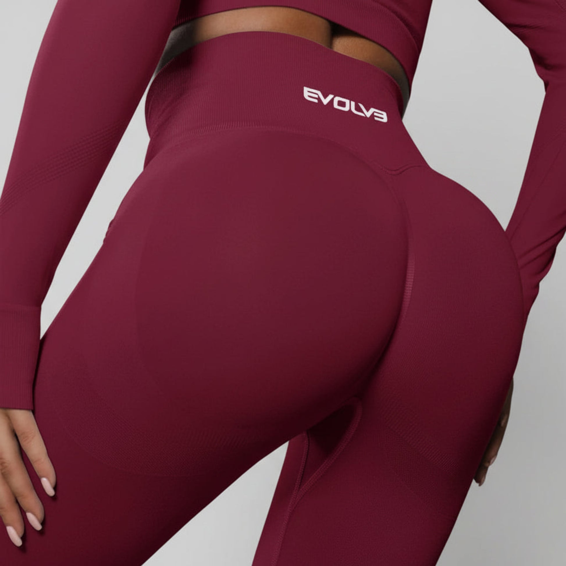 Maroon athletic outfit with 'Evolv3' logo on a dark background