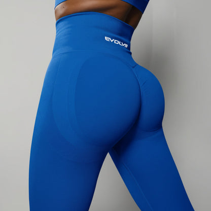 Blue leggings with 'Evolva' branding on a black background