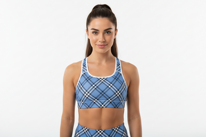 Woman wearing a blue plaid sports bra and leggings on a white background