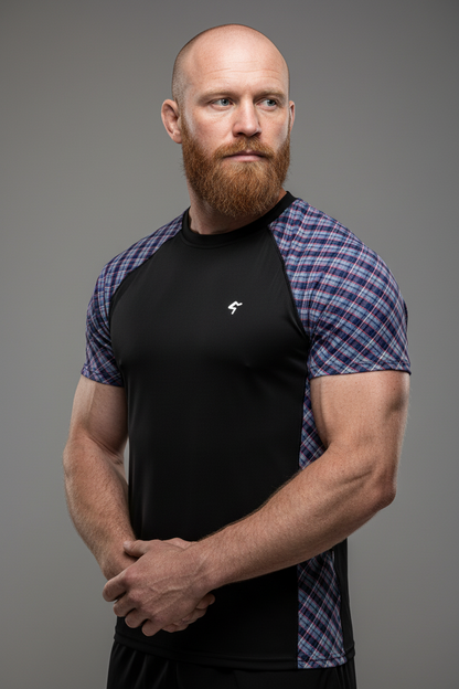Man wearing a black and plaid sports shirt against a gray background