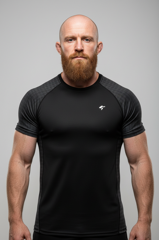 Man wearing a black athletic shirt with a logo on a gray background