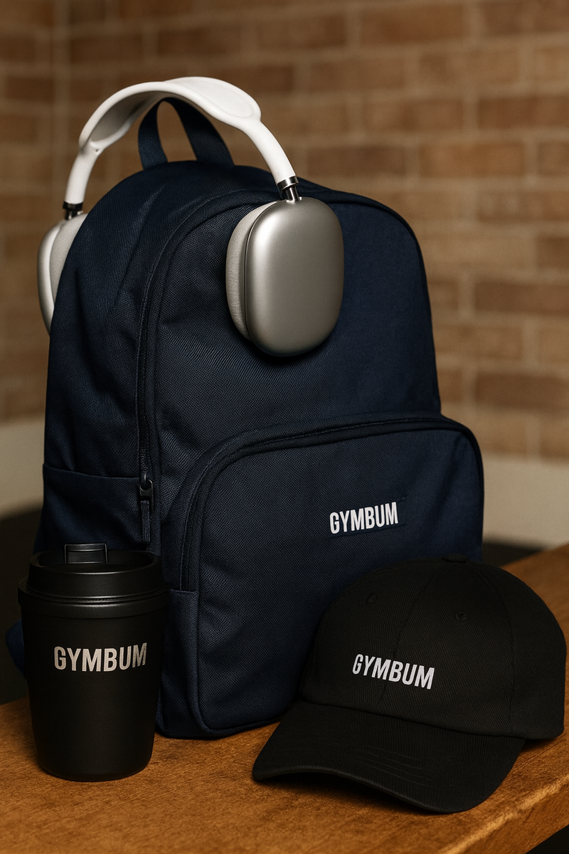 Black backpack, black tumbler, and black cap with 'GYMBUM' branding on a wooden surface.