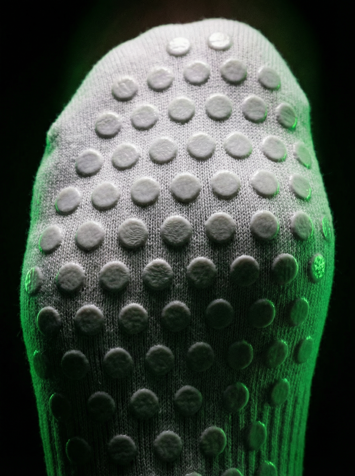 Close-up of white sock sole with raised non-slip grip dots
