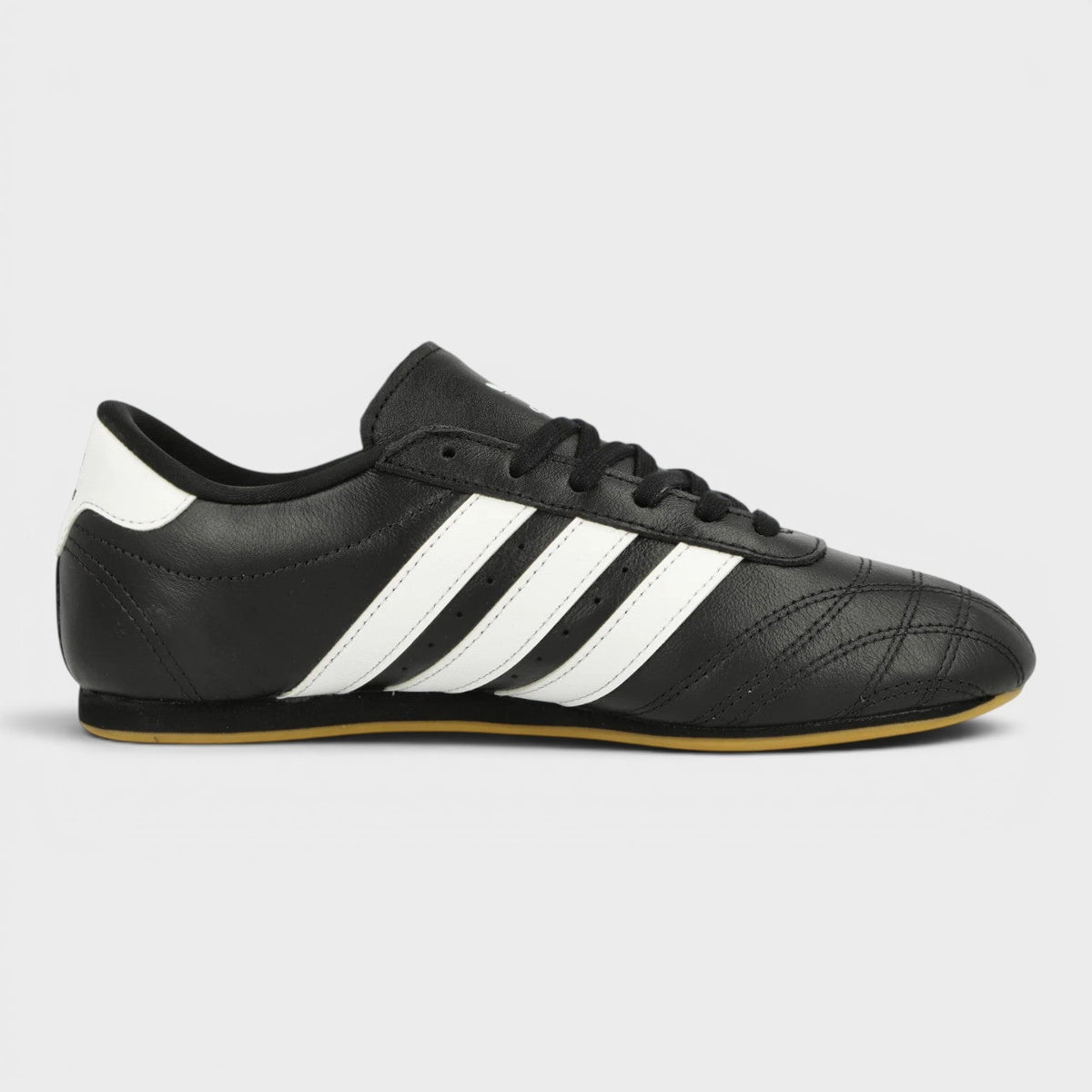 Black taekwondo shoes with three white stripes and lace-up front
