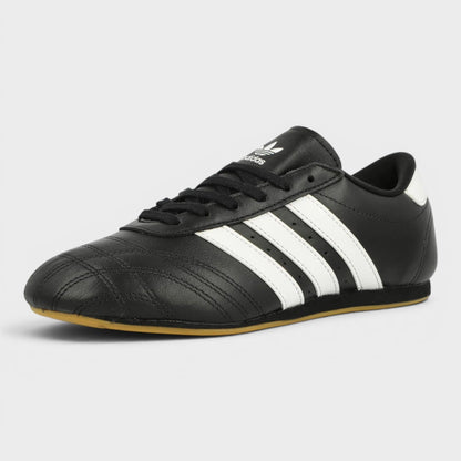 Black taekwondo shoes with white triple stripes and stitched paneling