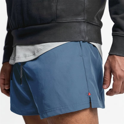 Person wearing blue shorts with a small red triangle logo on a white background
