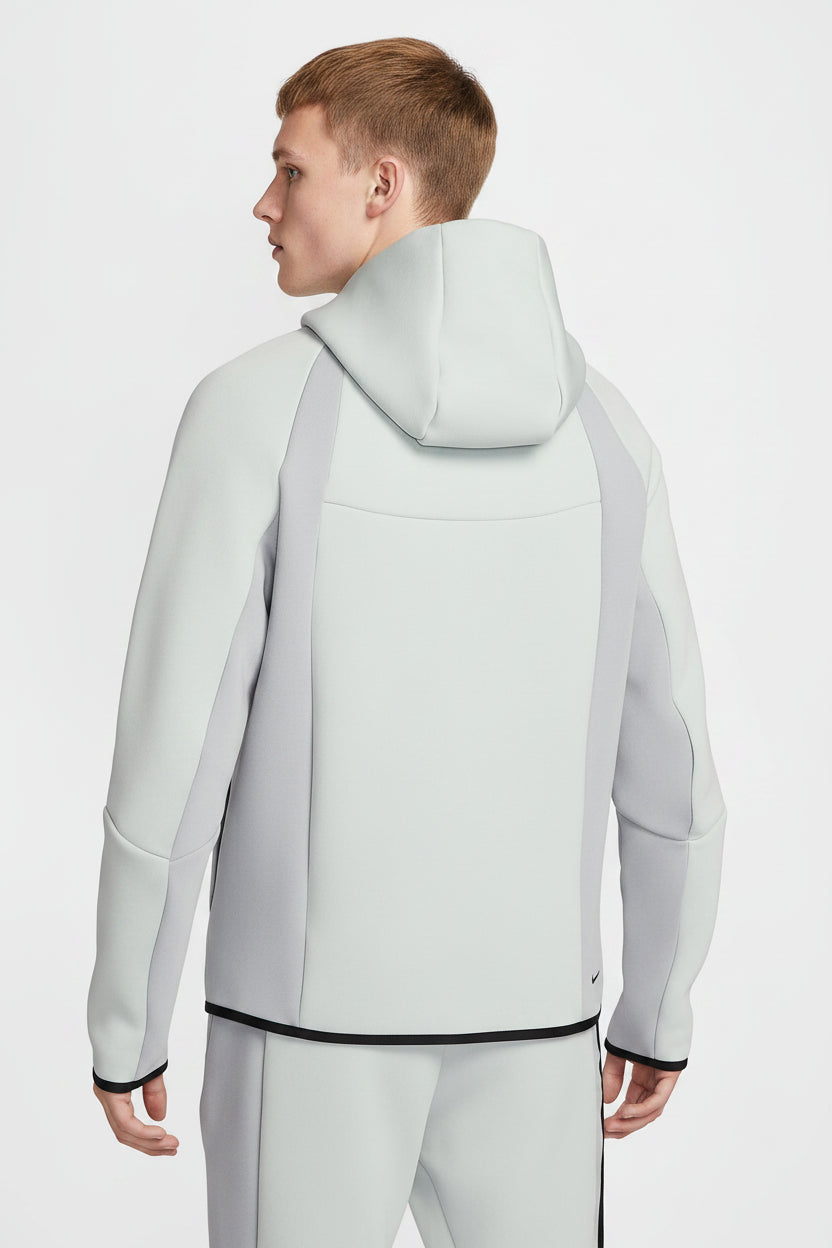 Person wearing a light gray hoodie with a hood on a white background