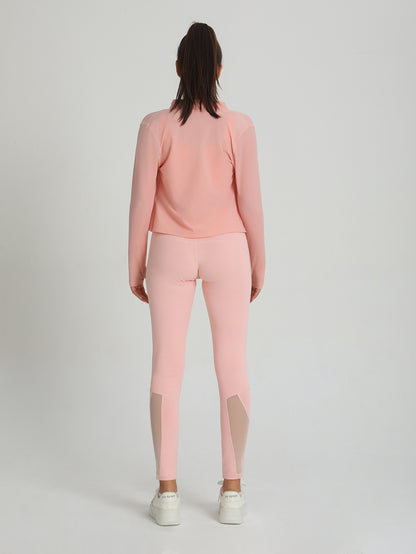 Peach-pink leggings and long-sleeve top with contrast mesh panels, back view