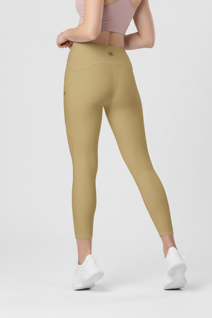 Person wearing beige leggings and white sneakers on a light gray background