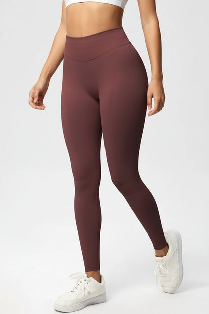 Maroon leggings worn by a person on a white background