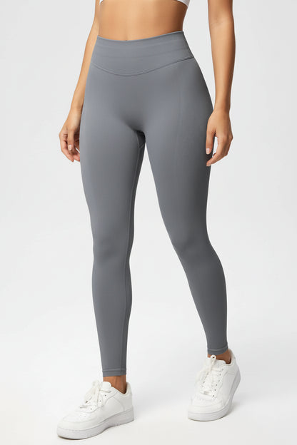 Gray leggings worn by a person on a white background
