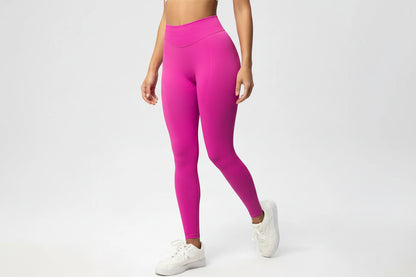 Person wearing bright pink leggings on a white background
