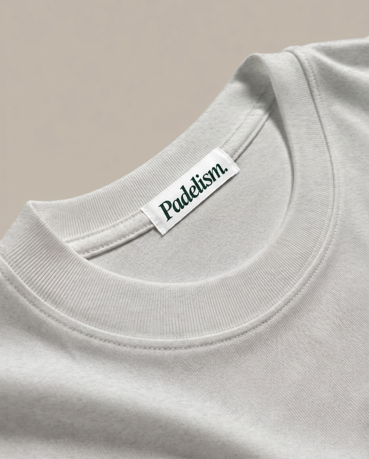 White heavyweight T-shirt close-up of ribbed crew neck and 'Padelism.' tag