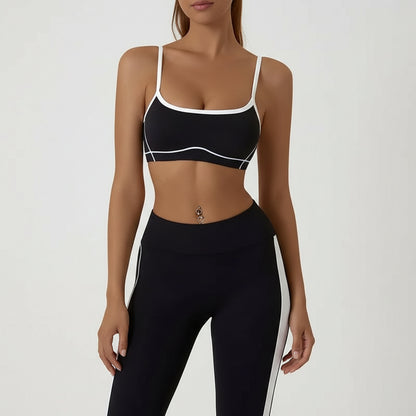 Black sports bra and leggings with white accents on a plain background