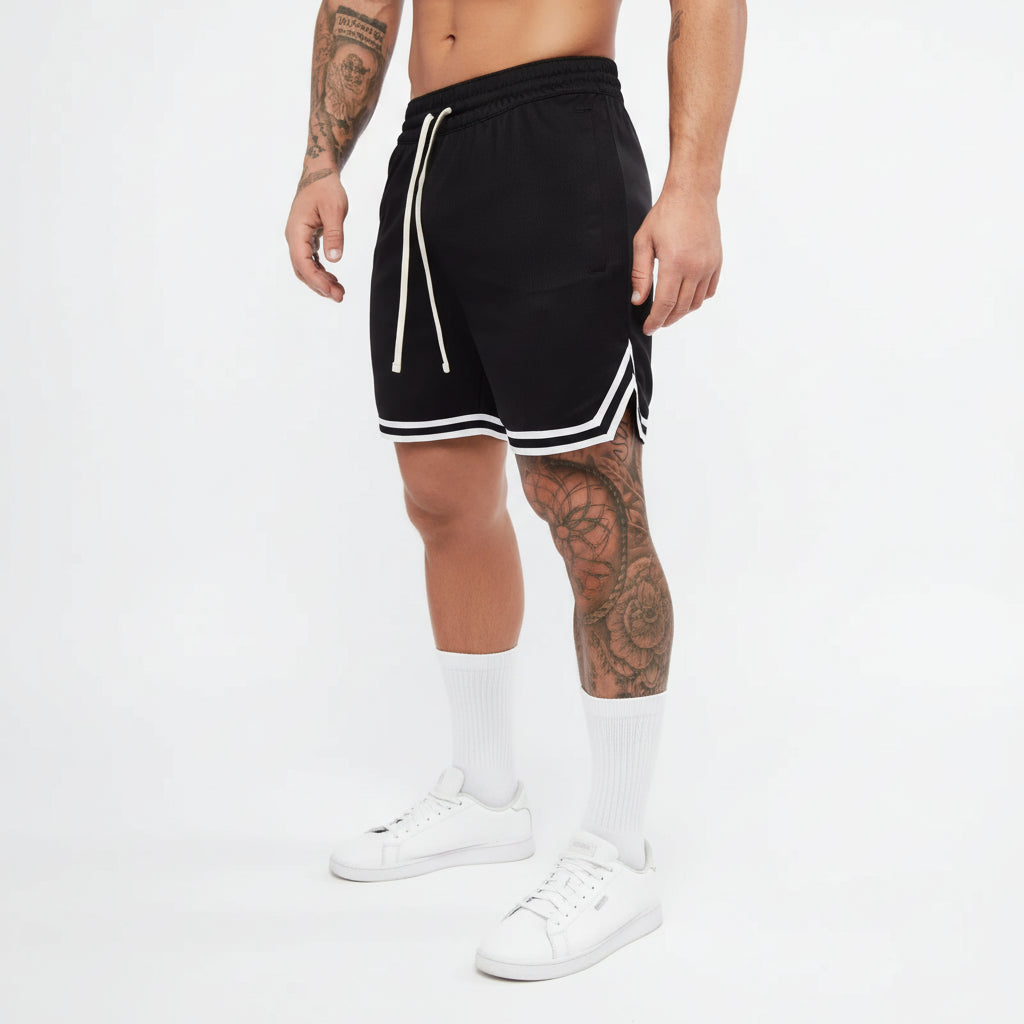 Person wearing black shorts with white stripes on a white background