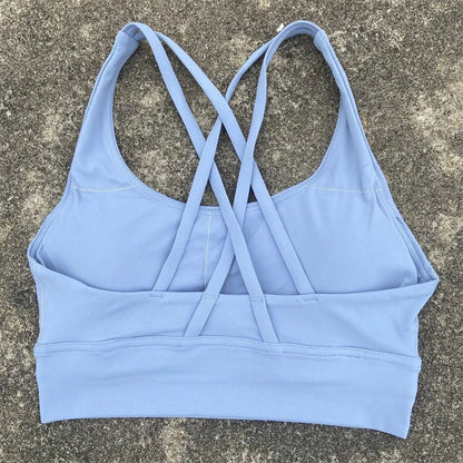Women's padded cross-back sports bra in light blue with crisscross back straps