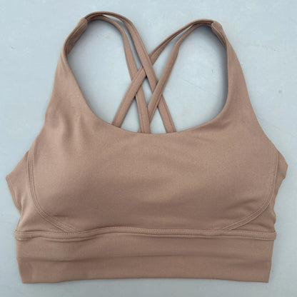 Tan padded sports bra with crisscross cross-back straps and wide supportive hem.
