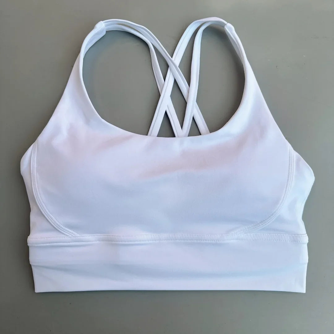 White padded sports bra with crisscross cross-back straps and smooth supportive band.